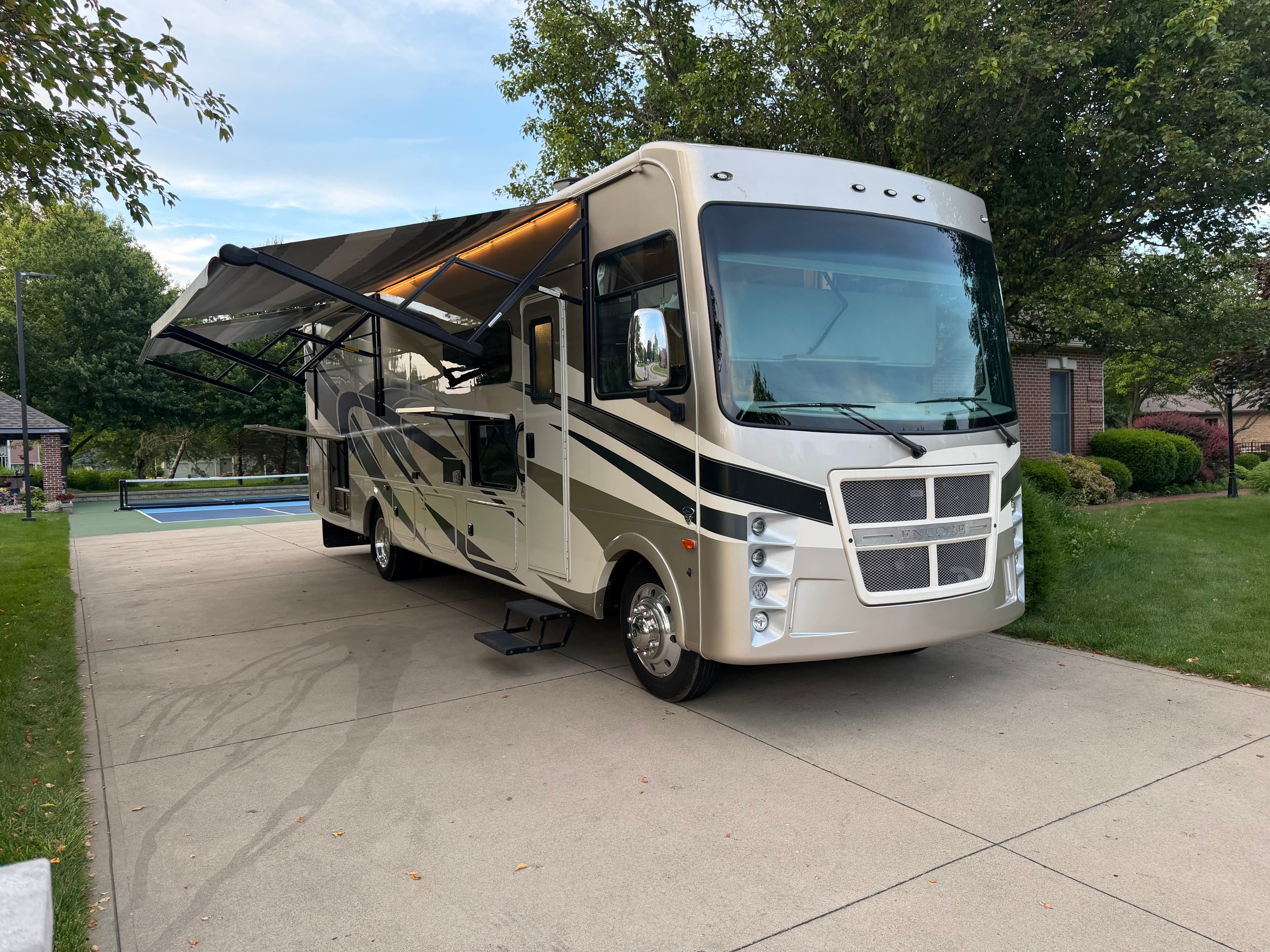 Front passenger-side view of the Coachmen Encore RV with the awning extended