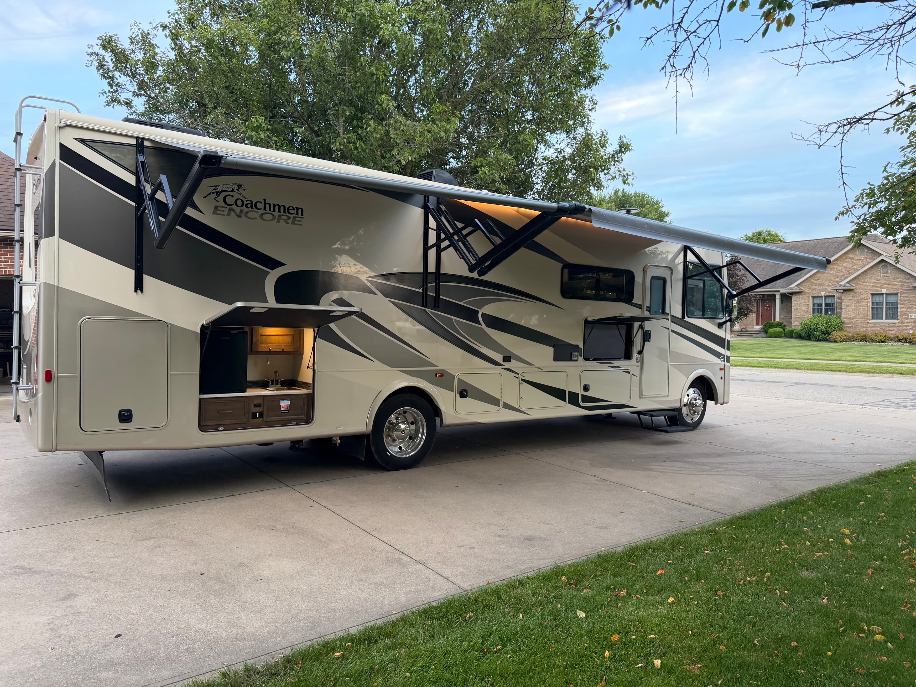 Side view of the Coachmen Encore RV showing the extended awning and exterior kitchen area